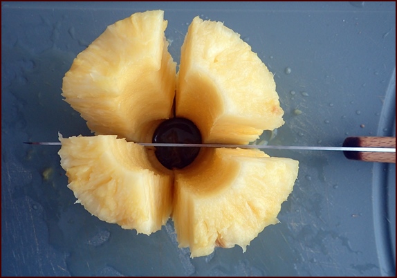 Cutting pineapple rings into chunks.