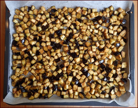 Seasoned eggplant on tray before roasting.