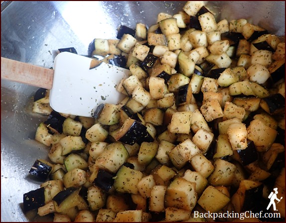 Seasoning cubed eggplant before roasting.