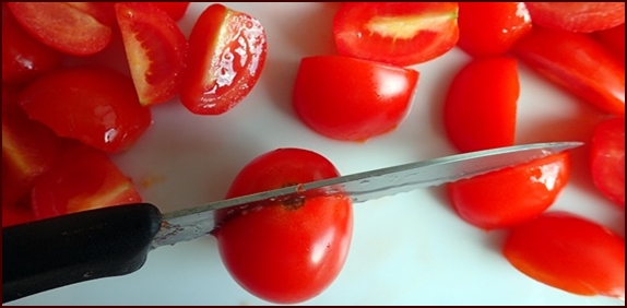 Cutting cherry tomatoes for dehydration.