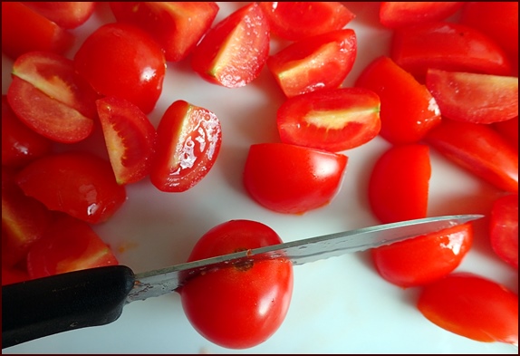 Cutting cherry tomatoes into quarters.