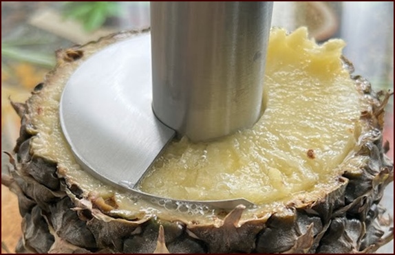 Turning pineapple corer with light pressure.