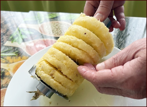 Spiral cut pineapple rings slide off handle end of corer.